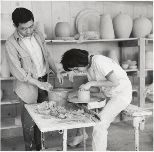 Henry Takemoto and student with pottery wheel, Scripps College