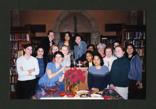 Scripps students and staff stand together smiling during Denison Library's 2000 Christmas tea, Scripps College