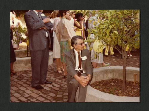 Muir Dawson sitting on a planter at Denison Library's 50th birthday celebration, Scripps College