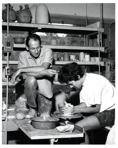 Paul Soldner and student with pottery wheel, Scripps College