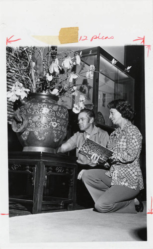 Man and woman observe vase, Scripps College