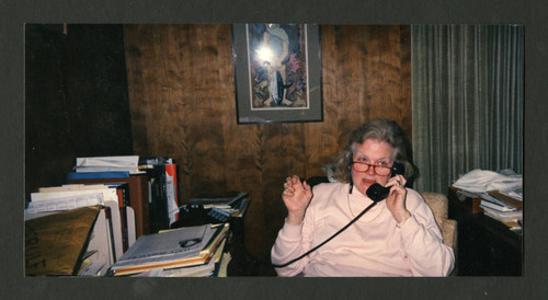 Judy Harvey Sahak speaking on her phone in her office, Scripps College