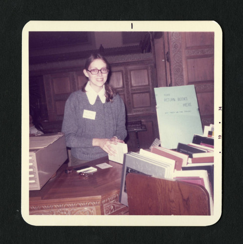 A Denison Library employee smiles while she orginizes book returns, Scripps College