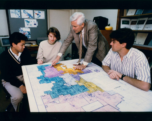 Students and a professor gather around a map, Claremont McKenna College