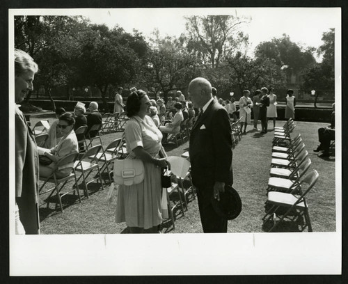 Dr. Frederick Hard speaking with a woman at the dedication of Drake Wing celebration, Scripps College