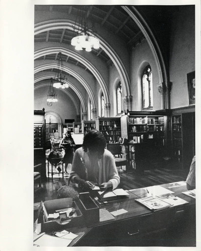 Patron at circulation desk of Denison Library, Scripps College