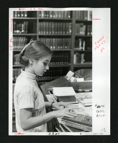 Scripps student studying blueprints at a desk in Denison Library, Scripps College