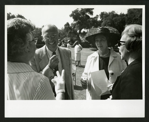 Four people banter at the dedication celebration of Drake Wing, Scripps College