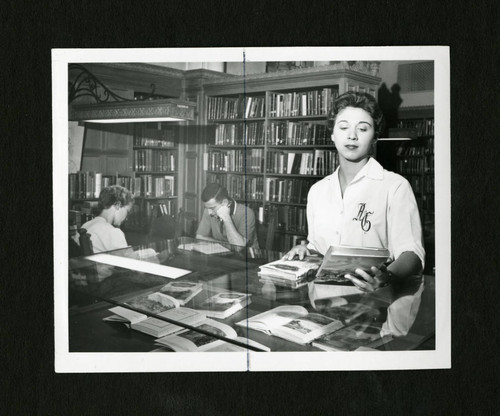 Scripps student looking at books displayed in Denison Library, Scripps College