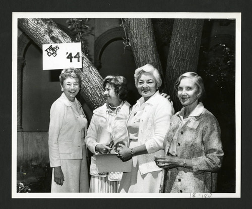 Four fellow Scripps alumnae standing together under a class of '44 sign, Scripps College