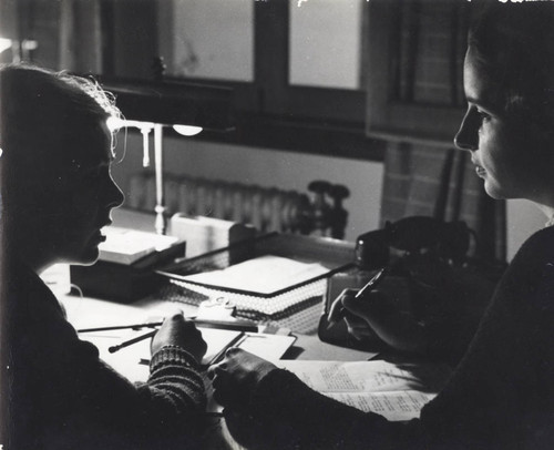 Profile of two students seated at a desk