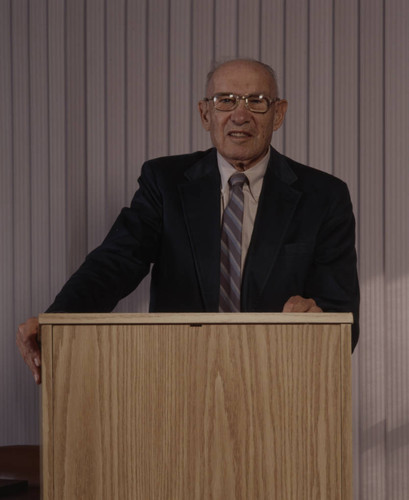 Peter Drucker standing behind a podium