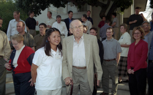 Drucker stands in front of a group with an individual