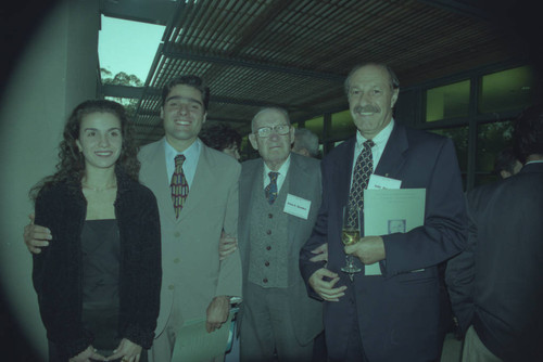 Peter Drucker and Odir Pereira standing next to two individuals