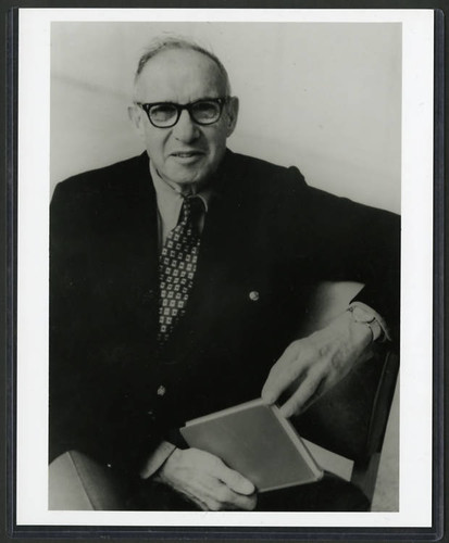 Photograph of Peter Drucker holding a book