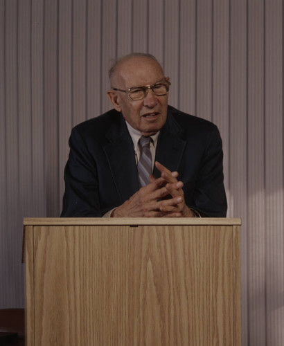 Peter Drucker standing behind a podium