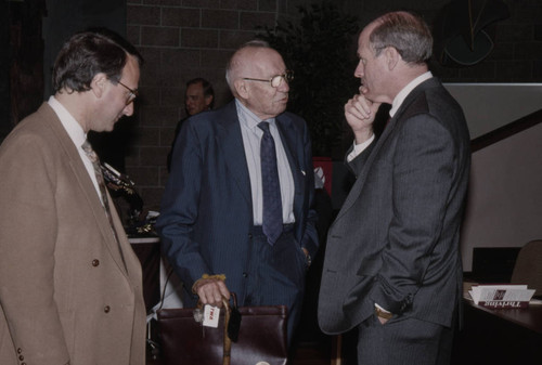 Peter Drucker standing between two individuals