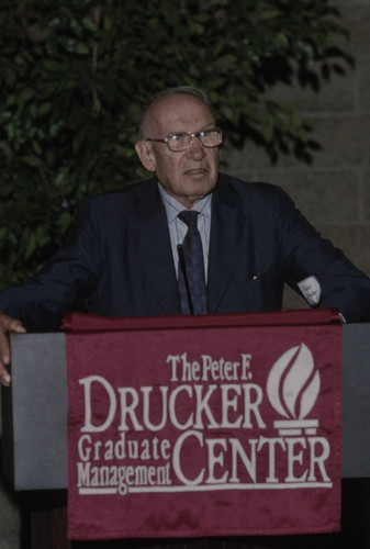 Peter Drucker standing behind a podium