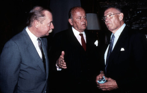 Peter Drucker standing next to two individuals