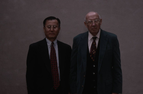 Peter Drucker stands next to an individual