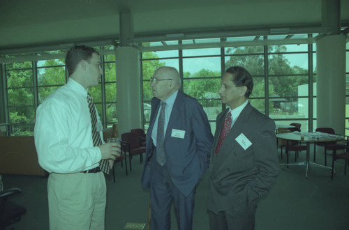 Peter Drucker and Deepak Shimkhada standing next to an individual