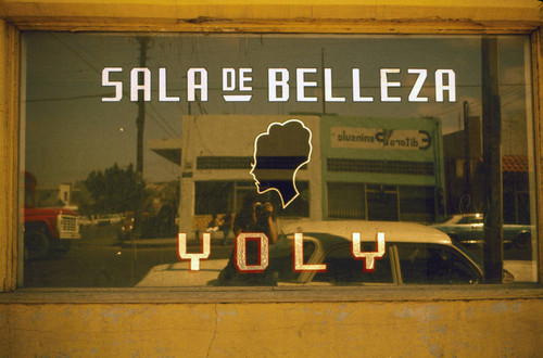 Elisa reflected in shopwindow of beauty salon