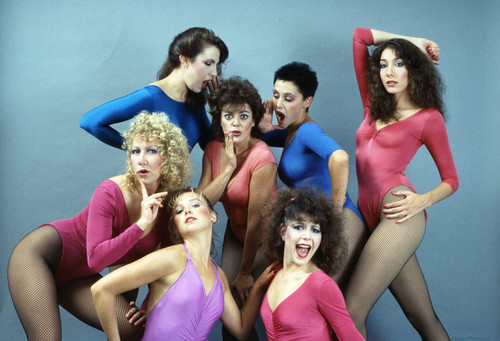 Dancers in multi-colored leotards and fishnet stockings