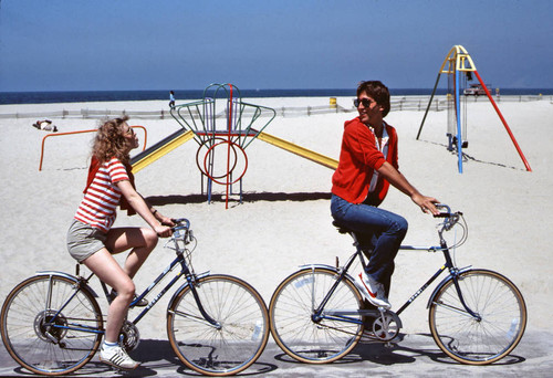 Venice couple bicycling on beach