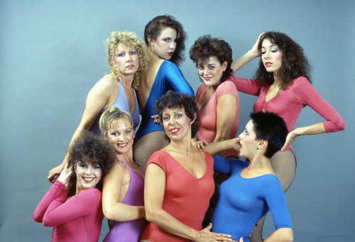 Dancers in multi-colored leotards and fishnet stockings