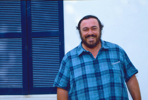 Luciano Pavarotti standing near window