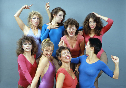 Dancers in multi-colored leotards and fishnet stockings