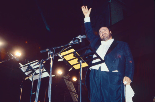 Luciano Pavarotti waving at concert