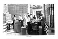 Cannery workers hand labeling cans