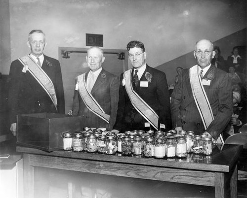 Four grange men with jars of money