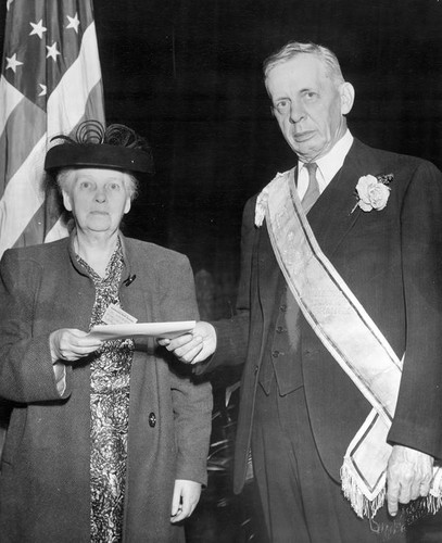 Man presents envelope to woman