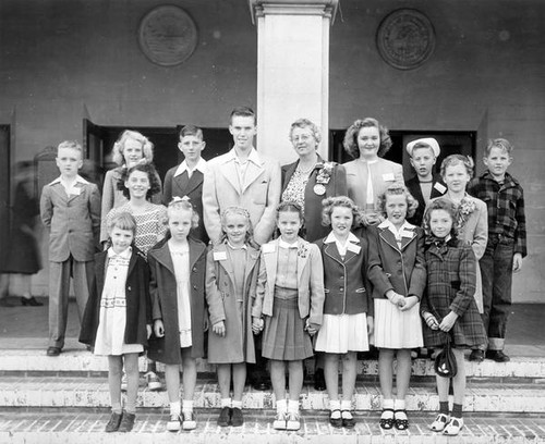 Children pose outside building