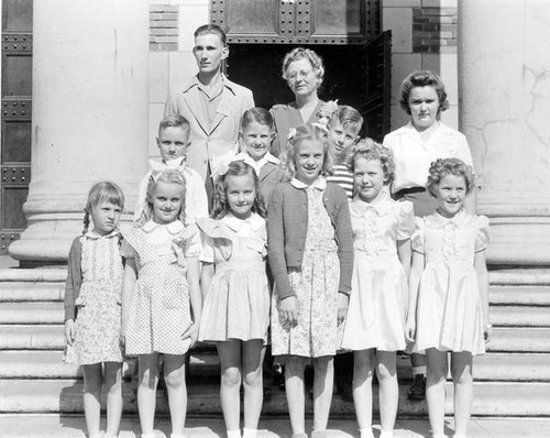 Children pose outside building