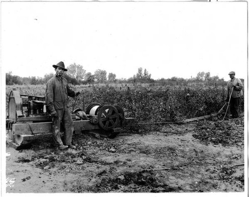 Two men and farm machinery