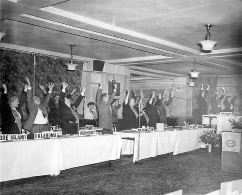 Grange convention attendees with arms raised