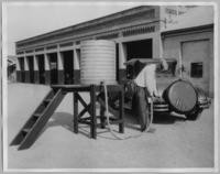 Unknown man pumping gas from a barrel