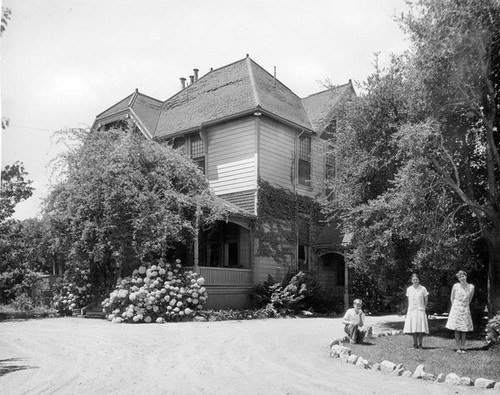 Three teenagers beside a house