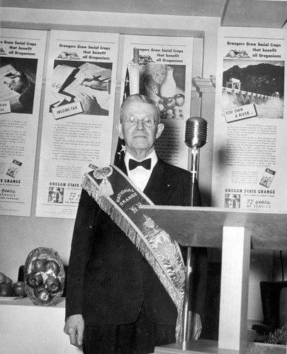 Unidentified man posing beside podium