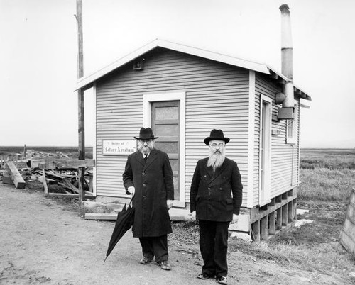 Two men in front of a house