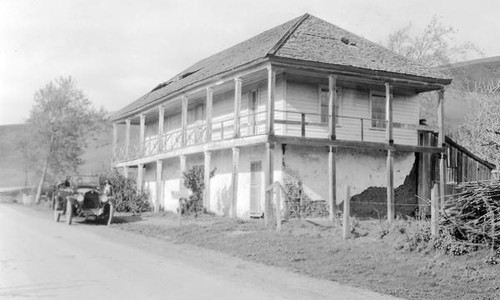 Automobile beside large house