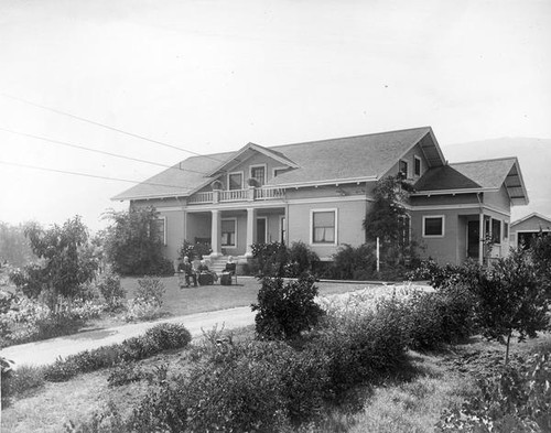 Three people in front of a house