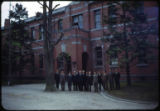 Men gather in front of a building