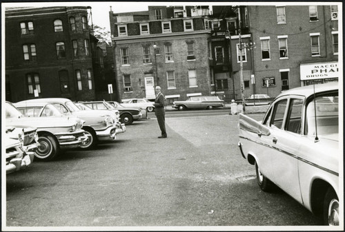 Charles Protzman standing in a parking lot, 1961-05