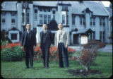 Three men standing near plants