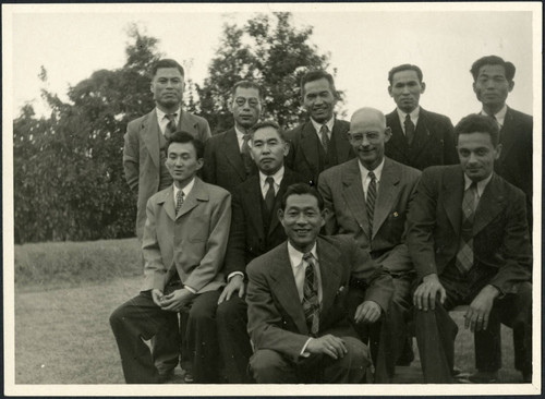 Charles Protzman and Homer Sarasohn sit with a group of men