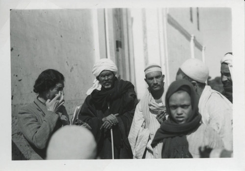Egyptian men standing outside building with Marianne Doresse